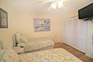 ein Wohnzimmer mit einem Bett und einem Flachbild-TV in der Unterkunft Ocean Village Club O18 in St. Augustine