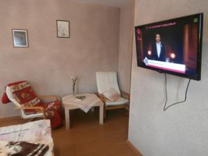a living room with a tv hanging on a wall at Agroturystyka Pod bocianem in Gołuchów