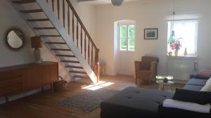 a living room with a staircase and a couch at Into The Green Apartment in Markt Nordheim