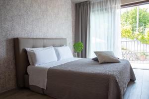 um quarto com uma cama grande e uma janela em B&B Villa Fulvia em Alba