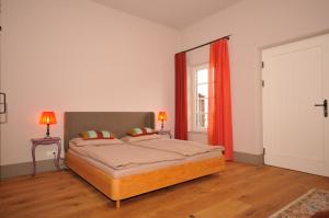 a bedroom with a bed with red curtains and a window at Landhaus-furth8 in Furth
