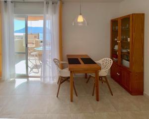 a dining room with a table and chairs and a balcony at Rubino in Calpe