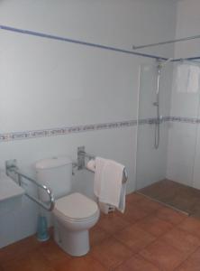 a white bathroom with a toilet and a shower at Hostal Rte. Casa Miguel in Matalascañas