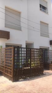 una valla frente a un edificio con ventanas en Le cocon de Sfax en Sfax