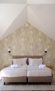 2 Betten in einem Zimmer mit 2 weißen Betten in der Unterkunft Casa Oliveira Esmeraldo - Guest Houses in São Vicente + 52 Fotos