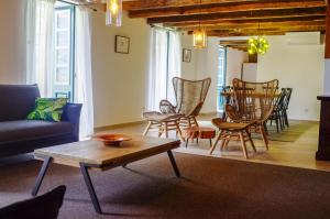 ein Wohnzimmer mit Sofa, Stühlen und einem Tisch in der Unterkunft Casa Oliveira Esmeraldo - Guest Houses in São Vicente