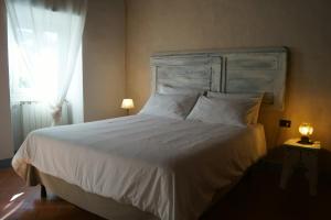 Un dormitorio con una gran cama blanca y una ventana en Casa Leopoldo, en Pratolino