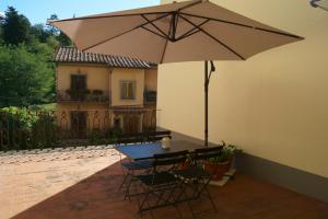 a table and chairs with an umbrella on a patio at Casa Leopoldo in Pratolino