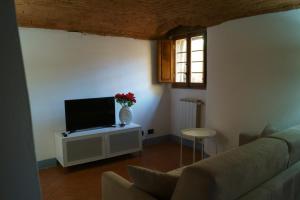 sala de estar con sofá y TV en Casa Leopoldo en Pratolino
