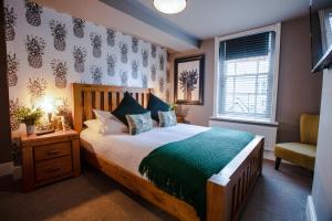 um quarto com uma cama grande e uma cadeira em The Wheatsheaf Pub, Kitchen & Rooms em Bingham