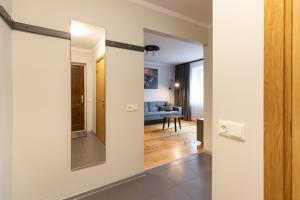 a hallway with a mirror and a living room at City center Gauja apartment in Valmiera