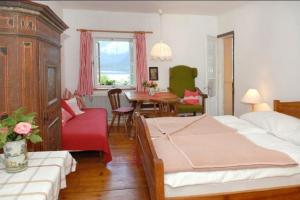 una camera da letto con due letti, un tavolo e delle sedie di Bräugasthof Hallstatt a Hallstatt