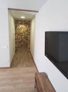 uma sala de estar com uma televisão de ecrã plano na parede em Apartamentai Vilniaus Street II em Siauliai