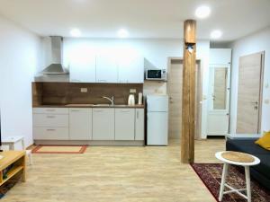 eine Küche mit weißen Schränken und einer blauen Couch in der Unterkunft Apartma Linhartov trg in Radovljica