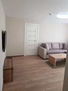 uma sala de estar com um sofá e uma mesa em Apartamentai Vilniaus Street II em Siauliai