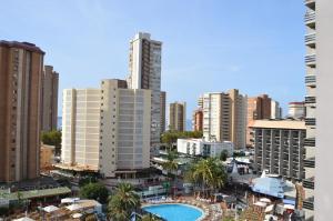 Blick auf eine Stadt mit hohen Gebäuden und einem Pool in der Unterkunft Apartamentos Provima in Benidorm