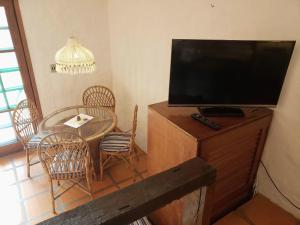 a living room with a table and a flat screen tv at Pousada da Lagoinha in Florianópolis