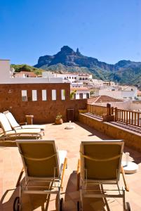 a patio with lounge chairs on the roof of a building at Hotel Rural Fonda de la Tea THE BEST LOCATION AND THE BEST VIEWS in Tejeda