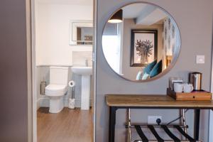 a bathroom with a mirror and a sink at The Wheatsheaf Pub, Kitchen & Rooms in Bingham