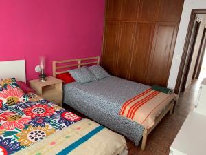 sypialnia z 2 łóżkami i różowymi ścianami w obiekcie Apartamento vistas catedral w mieście León