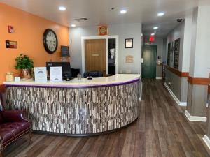 a lobby with a reception counter and a clock on the wall at Guest House Inn Medical District near Texas Tech Univ in Lubbock