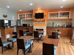 a restaurant with tables and chairs and a kitchen at Guest House Inn Medical District near Texas Tech Univ in Lubbock