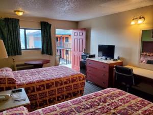 a hotel room with two beds and a television at Rodeway Inn Apopka South in Orlando