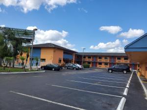 un estacionamiento con coches estacionados frente a un hotel en Rodeway Inn Apopka en Orlando