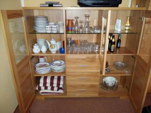 a wooden cabinet with plates and dishes on it at Ferienwohnung Riedberg in Balderschwang