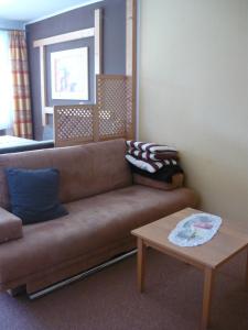 a living room with a brown couch and a table at Ferienwohnung Riedberg in Balderschwang