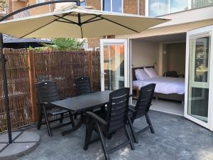 einen Tisch und Stühle mit Sonnenschirm auf einer Terrasse in der Unterkunft Casa del Cisne 2 in Zandvoort