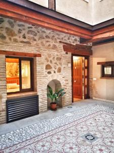 a house with a stone wall and a patio at El Aljibe de San Cipriano in Toledo