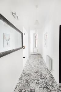 萊格尼察的住宿－Legnica Apartament 82m2 Delux 5，带有白色墙壁和图案地板的走廊