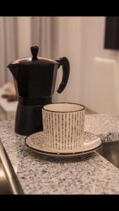 una cafetera y una taza en un mostrador en TURISMO LOS LANCES TARIFA( PARKING GRATUITO) en Tarifa