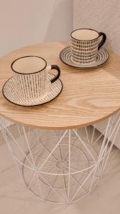 two coffee cups sitting on top of a wooden table at TURISMO LOS LANCES TARIFA( PARKING GRATUITO) in Tarifa