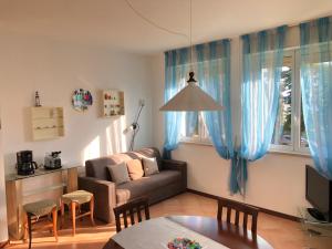 ein Wohnzimmer mit einem Sofa und einem Tisch in der Unterkunft Casa Alice Garda in Garda