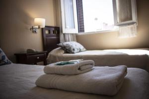 a hotel room with two beds with towels on them at Hotel Federico I in Concordia