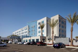 ベーカーズフィールドにあるHyatt Place Bakersfieldの大きな建物の前に車を停めた駐車場