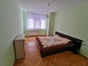 a bedroom with a bed and a wooden floor at Mountain view apartment in Vratsa