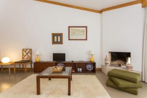 a living room with a couch and a table and a fireplace at 1Bed Apart Quinta do Lago in Almancil