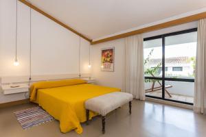 een slaapkamer met een geel bed en een groot raam bij 1Bed Apart Quinta do Lago in Almancil +16 foto's