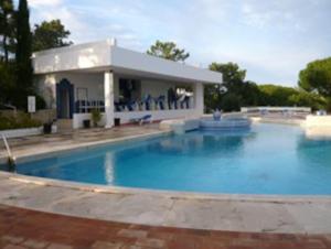 een groot zwembad voor een huis bij 1Bed Apart Quinta do Lago in Almancil