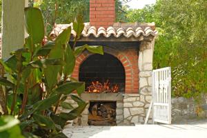 a brick oven with a fire inside of it at Spajić Apartments in Seget Vranjica