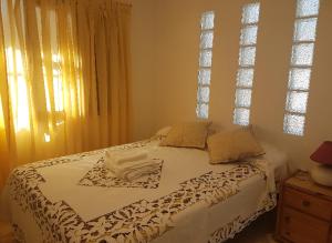 a white bed in a bedroom with a window at BED AND BREAKFAST- Alto La Viña- SUITE in San Salvador de Jujuy