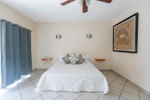 Un dormitorio con una cama blanca con almohadas. en Habitaciones Lucero 2 en Santa María del Oro