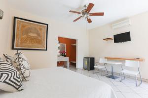 a bedroom with a bed and a table and a ceiling fan at Habitaciones Lucero 2 in Santa María del Oro