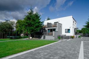 a white house with a tree in the yard at Apartamenty Szafir Stegna in Stegna