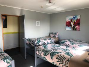 a room with two beds and a door to a bedroom at Ivorytowers Accommodation in Fox Glacier