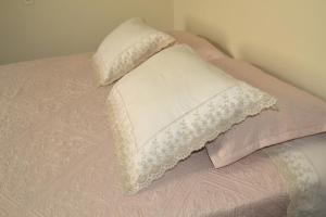 a bed with pink and white pillows on it at Casa Premiatto in Holambra