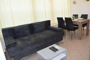 sala de estar con sofá negro y mesa en COMFY and BRIGHT Apartment, en Kranj